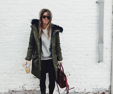 Crystal Seaver outside wearing a long coat holding an ice coffee